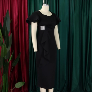 Detail of elegant black sheath dress featuring square neck, ruffles, and rhinestone buckle