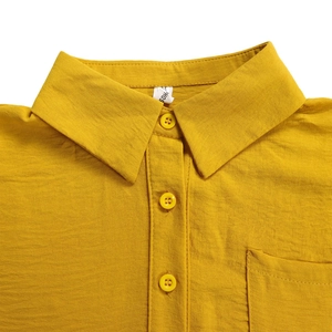 Macro detail of ginger yellow lapel shirt featuring fabric texture and patch pocket