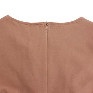 Close-up of the round neckline and invisible zipper on the pleated brown dress