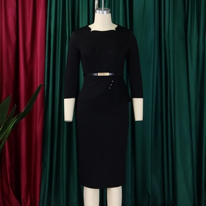 Détail de la robe noire avec volant plissé et ceinture à boucle dorée élégante