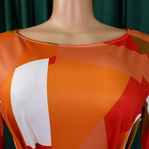 Détail de robe à imprimé géométrique coloré avec des blocs orange et rouges au col rond