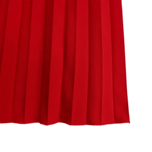 Detail showing high-quality vertical pleats and smooth hem edge of the red jumpsuit