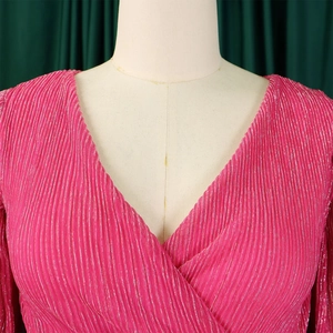 Detail of elegant fuchsia V-neck dress with pleated metallic fabric and long sleeves