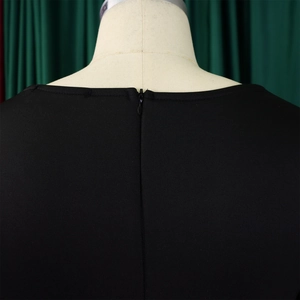 Detailed view of back neckline featuring an invisible zipper on solid black dress