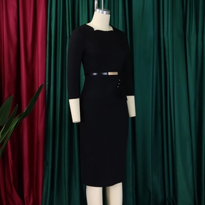 Détail d'une robe fourreau noire élégante avec fronces à la taille et boucle dorée