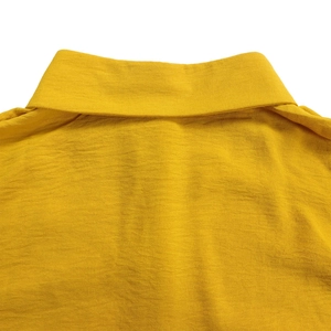 Detail of a bright yellow polo shirt collar showing breathable textured cotton fabric