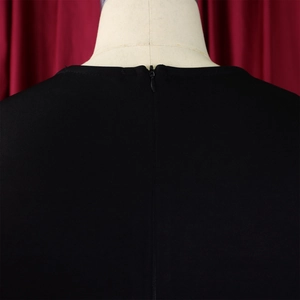 Close-up of black evening dress featuring an invisible back zipper on pleated fabric