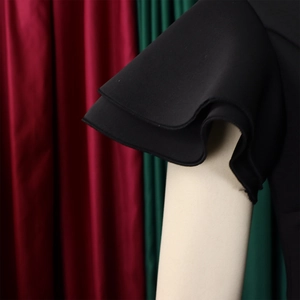 Detailed view of the elegant double-layer ruffled cuffs on a black evening dress