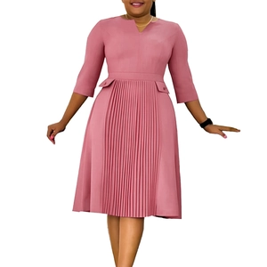 Detailed close-up of pink pleated hem and waist design on woman's midi dress