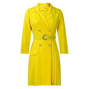Detailed macro view of yellow blazer dress featuring gold buttons and pleated skirt splice