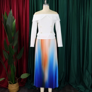 Detailed view of white off-shoulder top with gold buttons and pleated gradient skirt