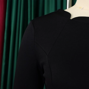Gros plan sur une robe noire élégante avec col en V et coutures d'épaule détaillées