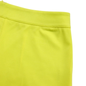 Detailansicht der neongelben Hose mit verdecktem Reißverschluss und präziser Nahtverarbeitung