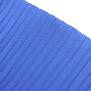 Close-up of royal blue pleated fabric with vertical textures and high-quality draping