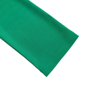Vue macro des poignets d'une robe en tricot vert avec coutures à double aiguille soignées