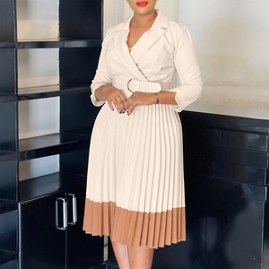 Détail de robe à revers bicolore avec jupe plissée et ceinture à boucle ronde