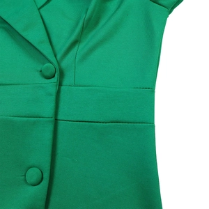 Détail de la robe vert émeraude montrant la taille cintrée et les boutons en tissu