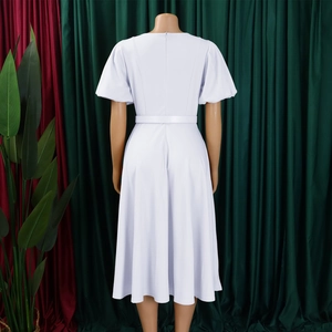 Détail de la robe à manches bouffantes taille haute avec ourlet évasé et ceinture