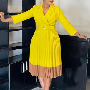 Détail de robe de bureau jaune avec ourlet plissé marron et ceinture à boucle ronde