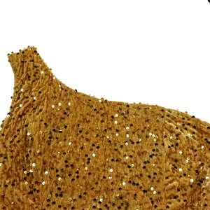 Detail shot of golden sequins on velvet fabric with one-shoulder asymmetrical tailoring