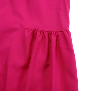 Detailed view of handmade pleats and fine stitching on rose red woven fabric shirt dress