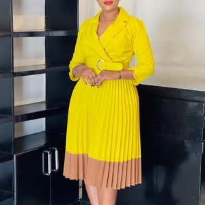 Détail d'une robe plissée jaune contrastée avec revers chic et ceinture à boucle métal