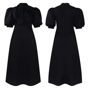 Detail view of black dress featuring puffy lantern sleeves and a bow tie neckline design