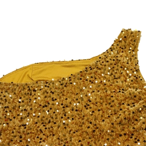 Detail of gold sequins on velvet fabric showing a one-shoulder evening gown texture