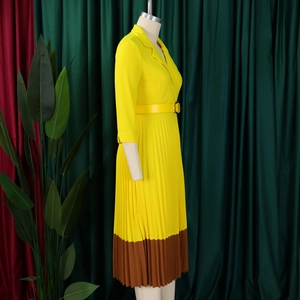 Détail d'une robe plissée jaune élégante avec ourlet contrasté et col à revers chic