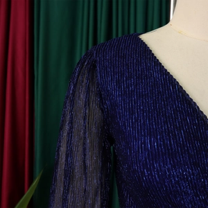 Detail view of navy blue pleated dress fabric with elegant metallic shimmer and sheer sleeves