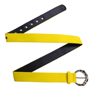 Detail view of yellow textured belt with unique twisted silver metal buckle and metal eyelets