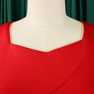 Close-up of the elegant asymmetric ruffled neckline on a red African bodycon dress