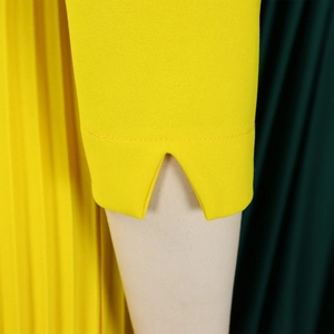 Détail du poignet d'une robe jaune avec encoche en V et texture de tissu raffinée