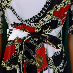 Détail de la taille nouée sur robe grande taille avec imprimés chaînes et boucles dorées