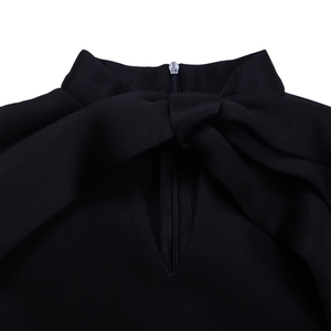 Detail of high collar with large bow and invisible back zipper on black dress