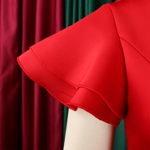 Close-up of elegant double-layered ruffle sleeves on a solid red formal dress