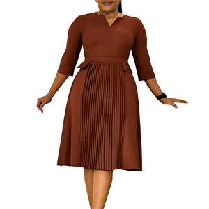 Detail view of rusty red midi dress showing pleated skirt design and three-quarter sleeves