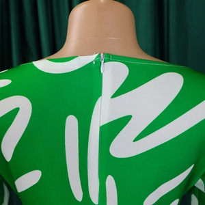 Detailed view of invisible back zipper and green abstract floral print on the dress
