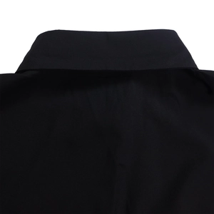 Close-up detail of the classic collar and shoulder seam of a black button-down shirt dress