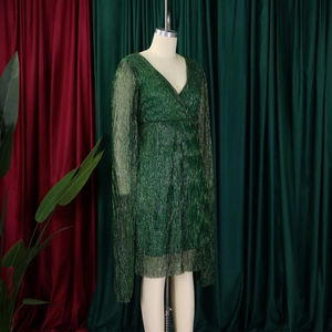 Detail of elegant V-neck long sleeve dress in metallic green fabric with pleated texture