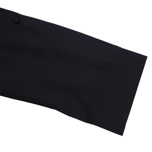 Detailed close-up of a black woven shirt sleeve featuring a smooth resin button and clean cuffs