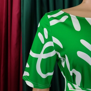 Detail of round neckline and abstract white print on a vibrant green short-sleeve dress