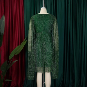 Detail of dark green metallic cape sleeves and pleated texture on the evening gown
