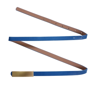 Détail de ceinture fine en cuir bleu pour femme avec boucle dorée et doublure marron