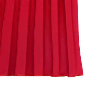 Close-up of red pleated dress hem showing fine stitching and polyester fabric texture