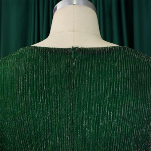 Macro view of green pleated fabric dress with invisible back zipper and metallic shine