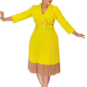 Détail de la robe plissée jaune avec ourlet contrasté, col blazer et ceinture à boucle