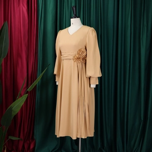 Close-up of beige V-neck dress with 3D waist flower and elegant side pleated details