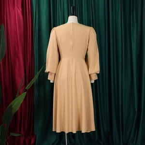 Detailed back view of khaki A-line dress featuring a high waist and hidden zipper closure