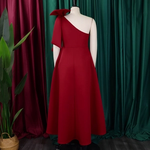 Detail of elegant one-shoulder dark red evening gown with a large bow and A-line skirt